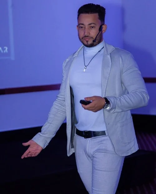 Dim Farnese conduzindo um treinamento presencial no palco
